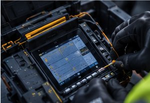 Engineer using an OTDR and fusion splicer to test and splice fibre optic cable